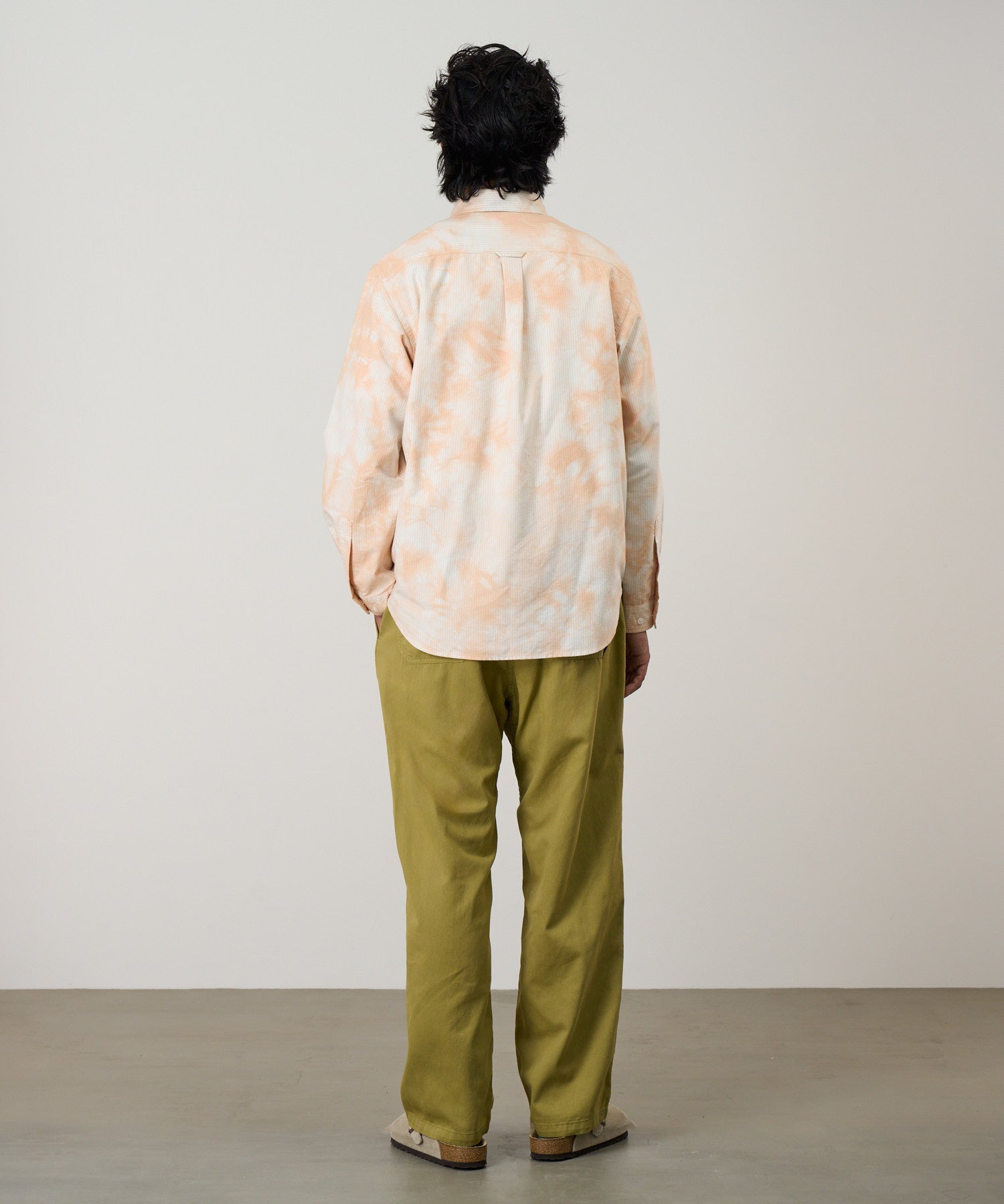 Model wearing Gramicci checkered ombre shirt mustard stripe relaxed fit oxford shirt back view casual style