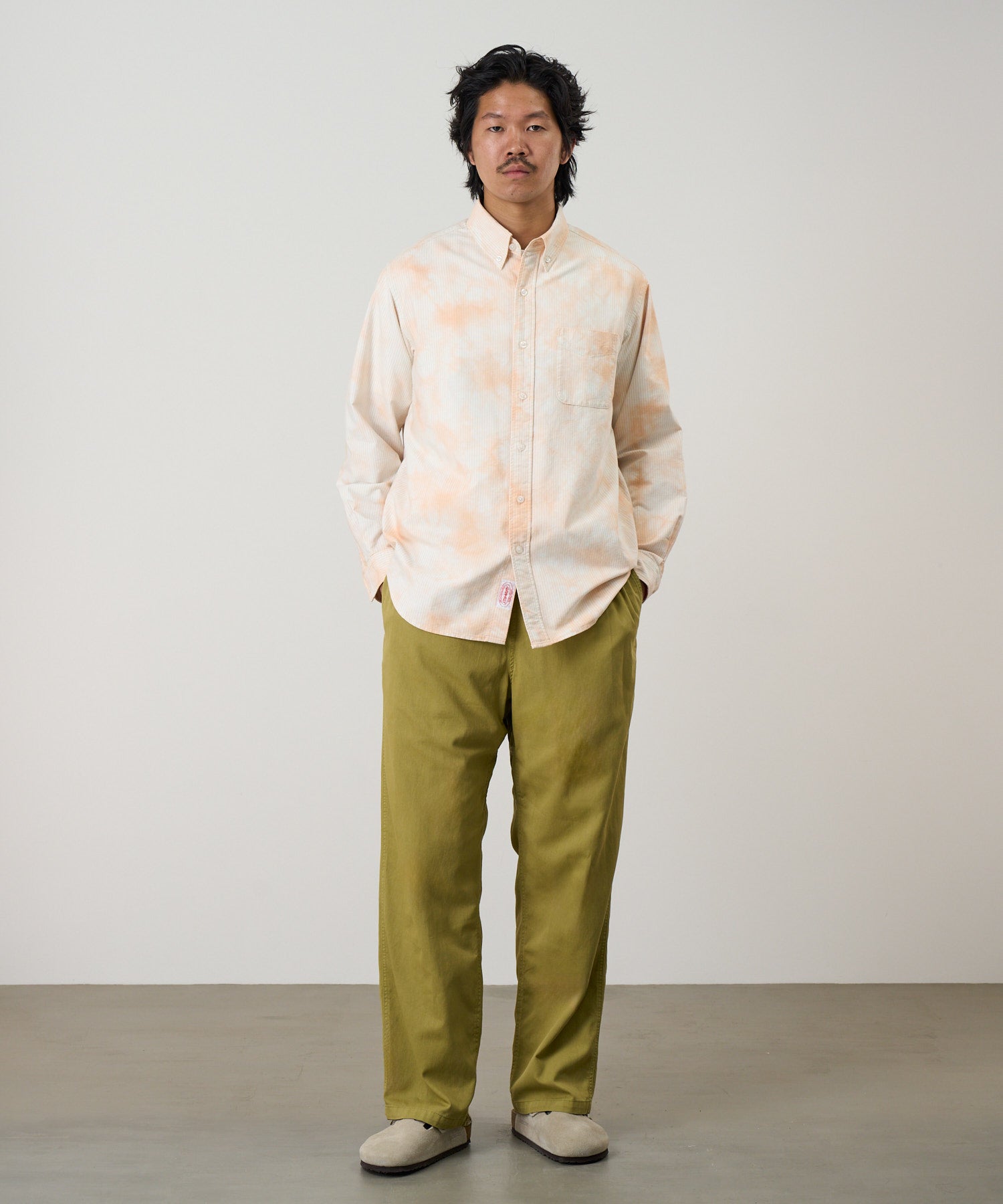 Model wearing Gramicci checkered ombre shirt mustard stripe relaxed fit oxford shirt front view casual style