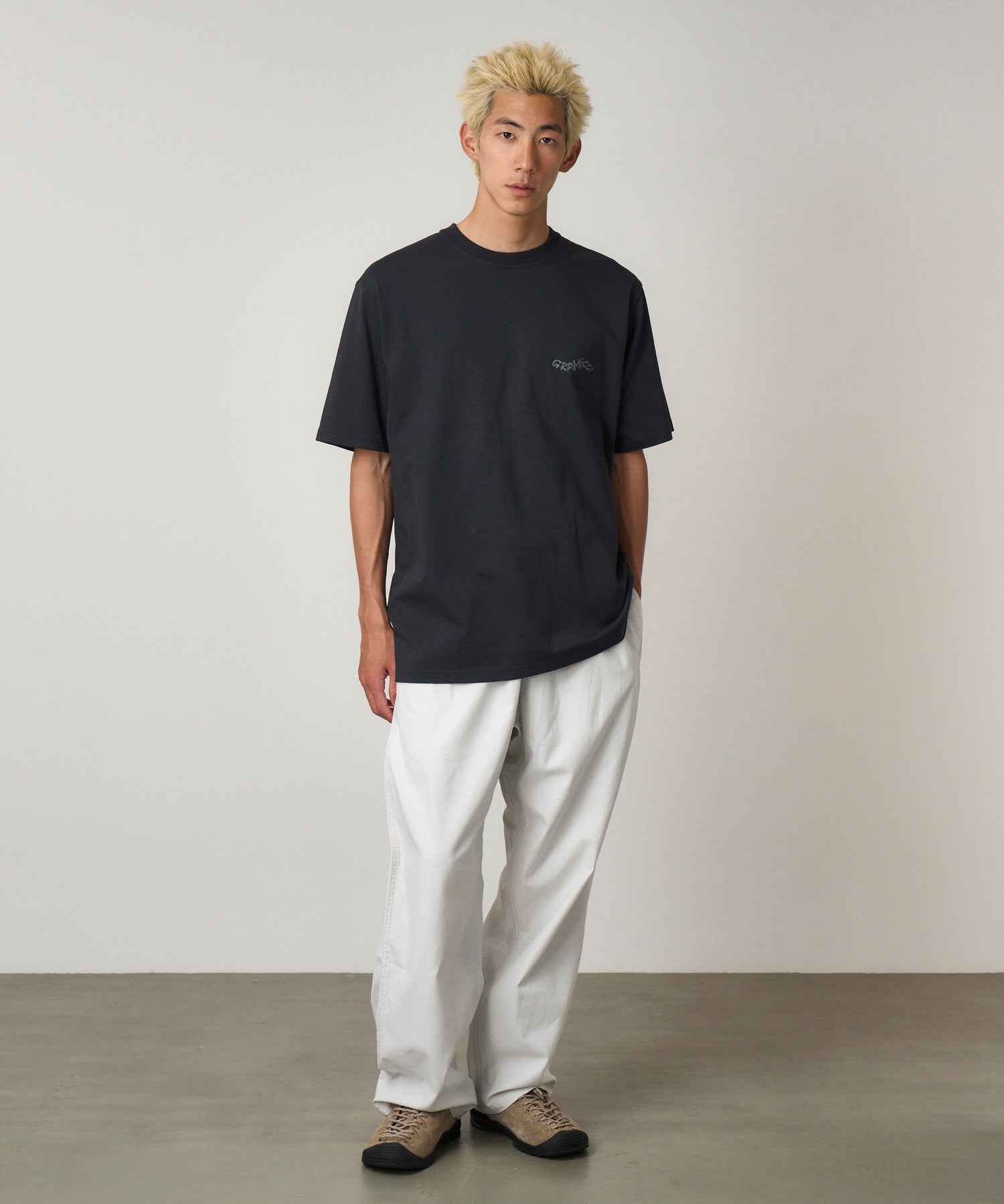 Model wearing Gramicci Gecko Tee Vintage Black in eco cotton with dry-touch fabric, relaxed fit and bold back graphic for everyday wear.