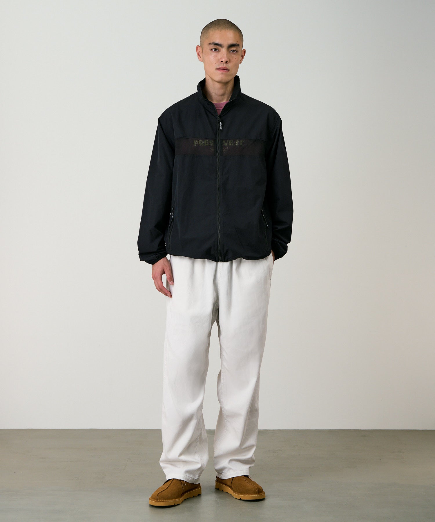 Front view of a model wearing Gramicci Guide Jacket Black with lightweight water-repellent fabric, zip pockets and everyday comfort.