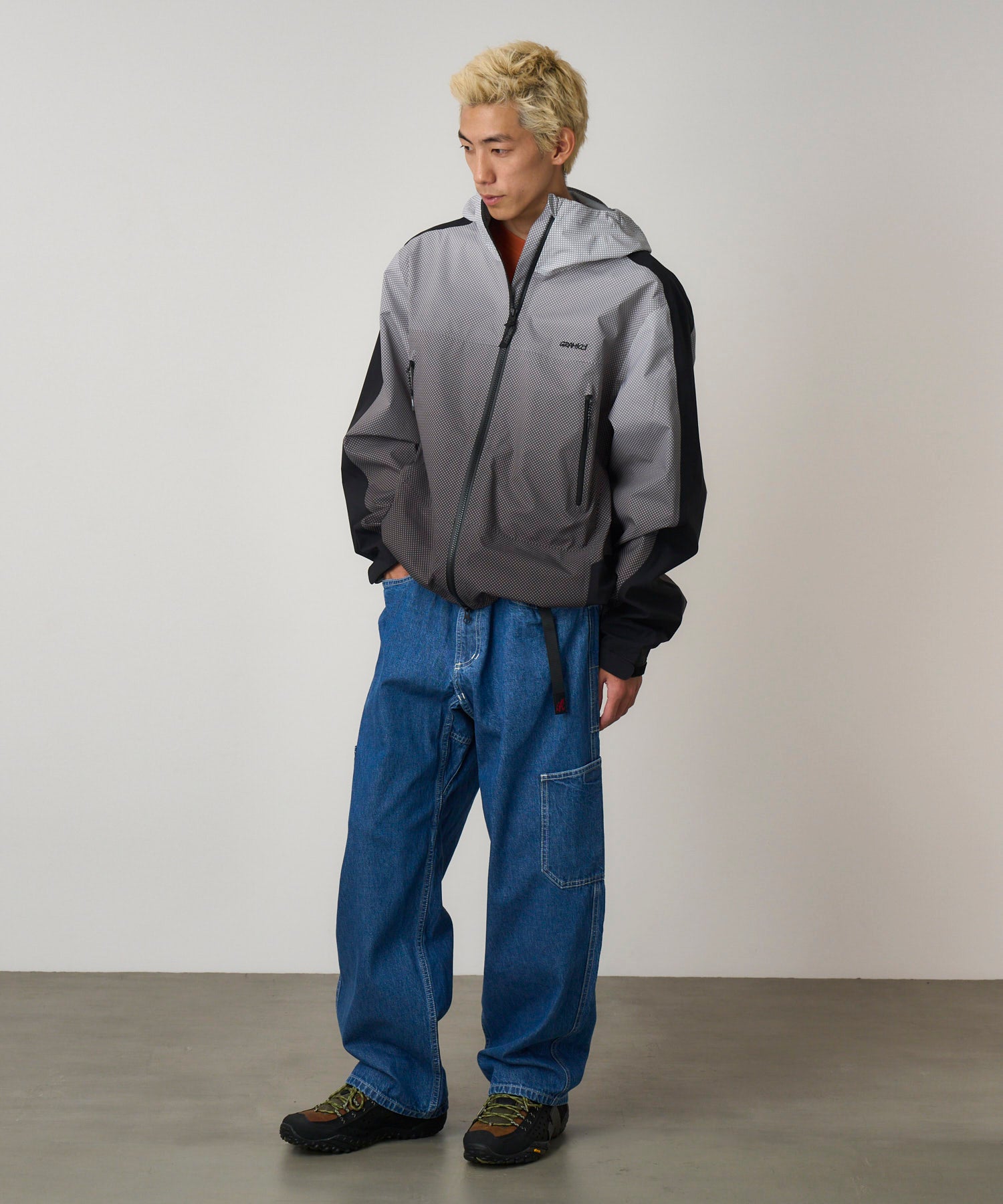 Back view of model wearing Gramicci Rock Slide Denim Pant Light Wash in 11oz eco cotton denim with relaxed fit, cargo pockets and integrated belt.
