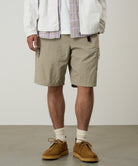 Model wearing Gramicci Nylon Cliff Short Milk Tea with lightweight recycled nylon, cargo pockets and an adjustable belt for everyday comfort.