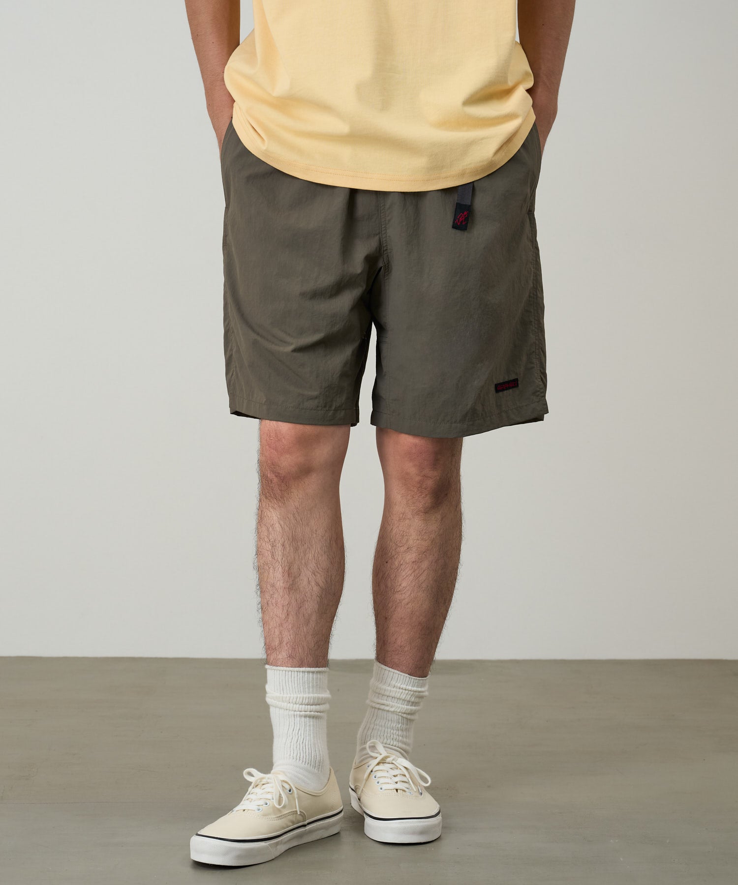 Model wearing Gramicci Nylon Packable G-Short Granite featuring lightweight recycled nylon, relaxed fit and an adjustable belt for everyday comfort.