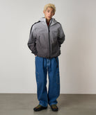 Model wearing Gramicci Rock Slide Denim Pant Light Wash in 11oz eco cotton denim with cargo pockets, relaxed fit and integrated belt.