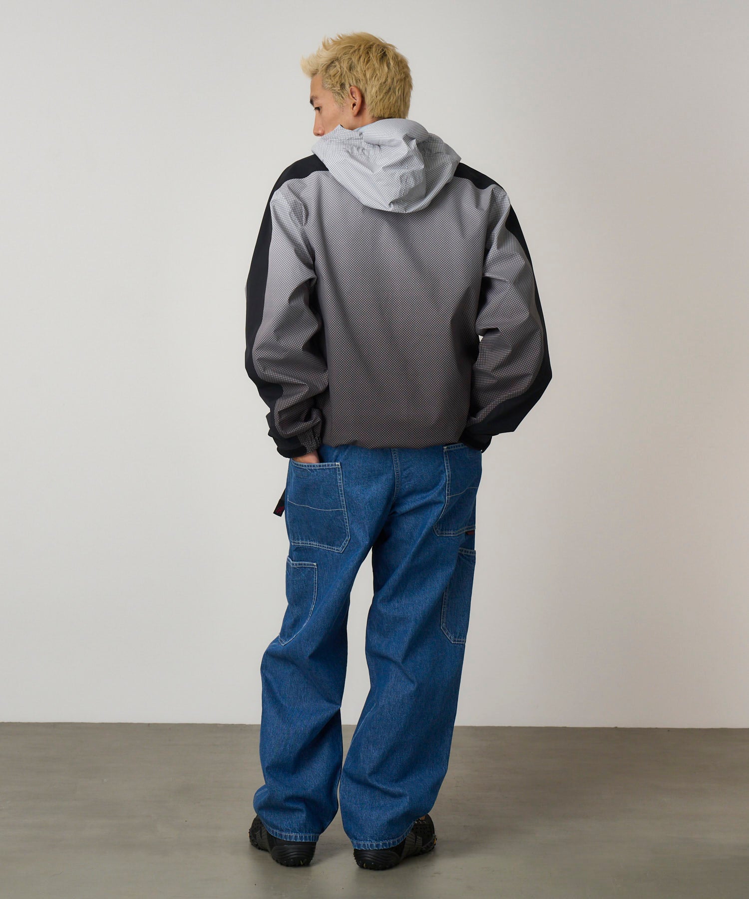 Side view of model wearing Gramicci Rock Slide Denim Pant Light Wash in 11oz eco cotton denim with cargo pockets and relaxed fit.