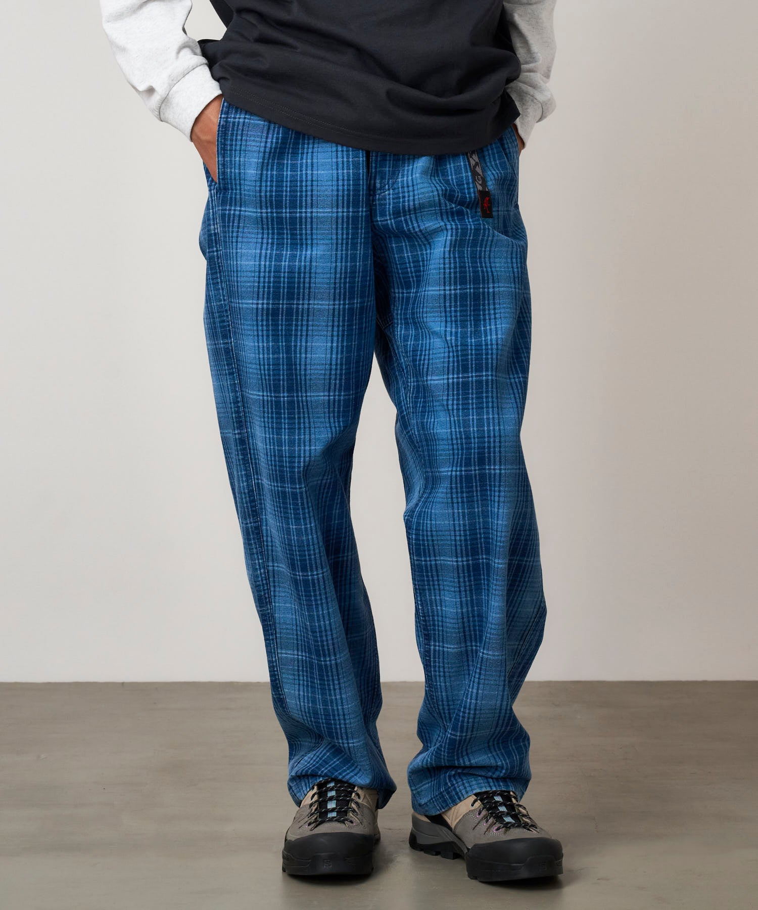 Full body view of model wearing Gramicci O.G. denim plaid pant indigo checkered relaxed fit straight leg trousers