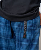 Model wearing Gramicci O.G. denim plaid pant indigo checkered in relaxed fit showing movement and everyday outdoor wear