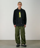 Model wearing Gramicci olive nylon trek pants showing relaxed outdoor fit