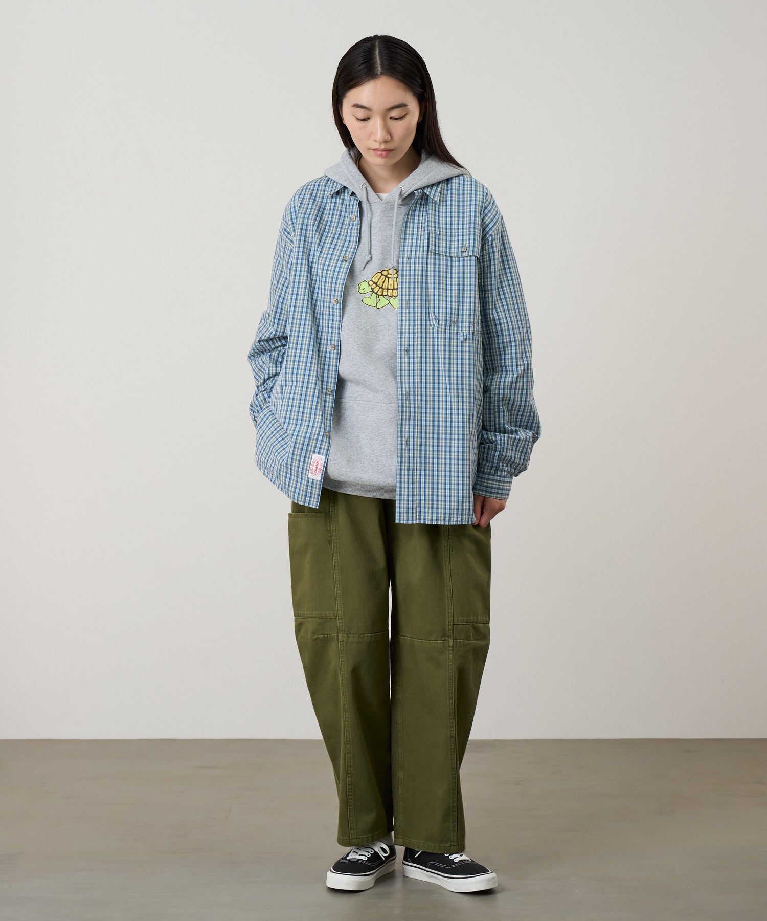 Model wearing Gramicci W’s Voyager Pant Army Pigment relaxed fit outdoor pants full body side view